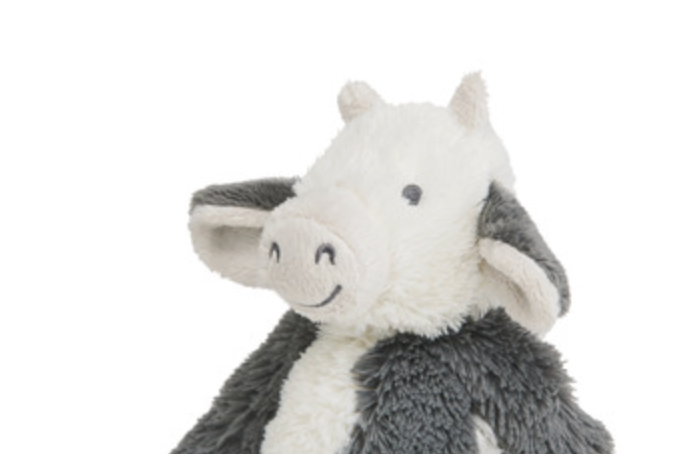 A plush stuffed animal cow with a white face and ears, dark gray body, and a simple embroidered smile on a plain white background.