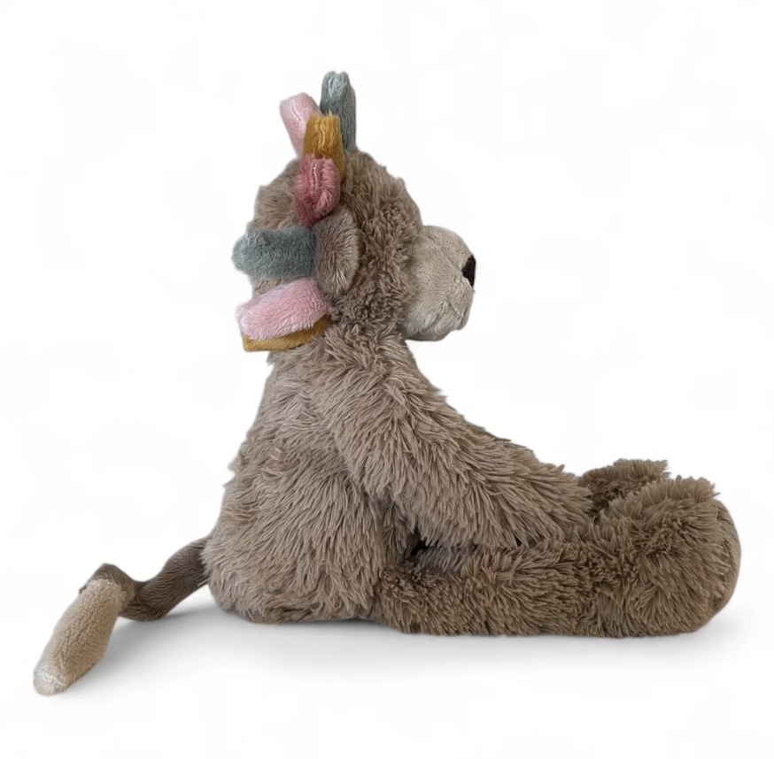 A plush stuffed animal shaped like a seated fox or rabbit in warm taupe-brown fur, with pastel multicolor accents on its ears and a small black nose, photographed on a clean white background.