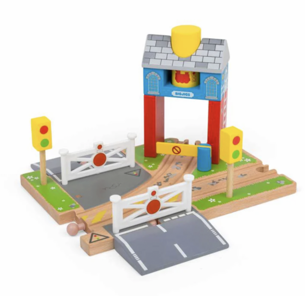A wooden toy train crossing set with a signal tower, two traffic lights, two crossing barriers, and a curved wooden track on a white background.