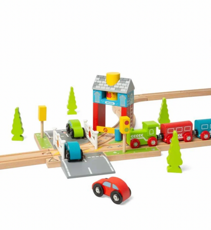 A wooden toy train set with a small train, tracks, a station platform, signal posts, trees, and a separate red car on a white background.