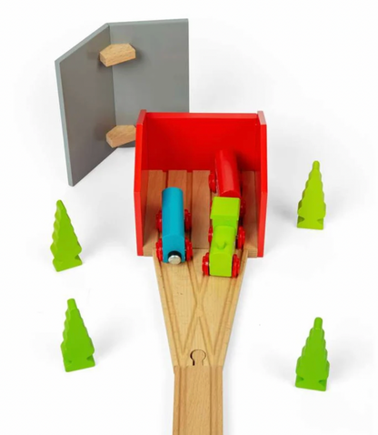 A wooden toy train set with a red tunnel, light wood tracks, a blue train car, a red and green train car, and four small green tree shapes on a white background.