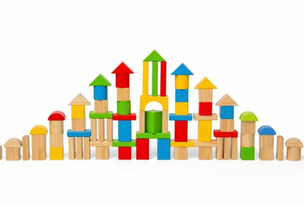 A set of colorful wooden building blocks arranged to form a castle-like structure on a plain white background.