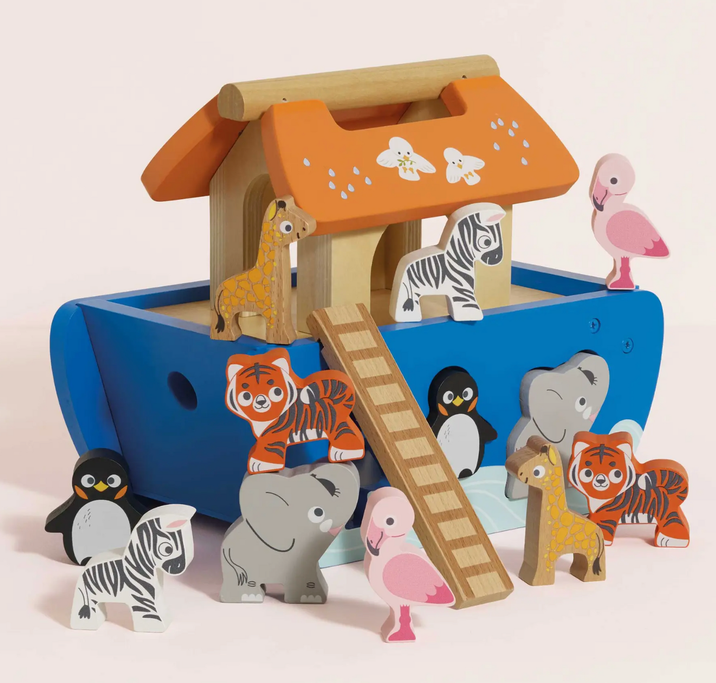 A wooden Noah's Ark toy set with a blue ark, orange roof, ladder, and painted animal figures including giraffes, zebras, tigers, penguins, elephants, flamingos, and a pink flamingo on a light beige background.