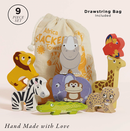 A 9-piece wooden toy set featuring safari animals and a drawstring bag. The set includes a lion, zebra, giraffe, crocodile, leopard, monkey, and a bird, with a cream-colored drawstring bag printed with cartoon animals and the text 'Africa Stackers Tower'.