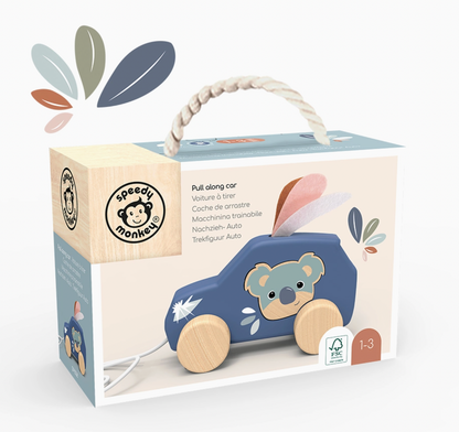 Boxed toy product for children on a clean white background. The packaging shows a blue pull-along car with a koala face, natural wood wheels and handle, and printed text including 'speedy monkey' and 'Pull along car'.