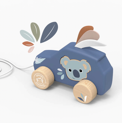 A wooden koala car pull toy in slate blue with natural wood wheels and leaf-shaped pull tabs, shown on a clean white background with a white cord entering from the left.