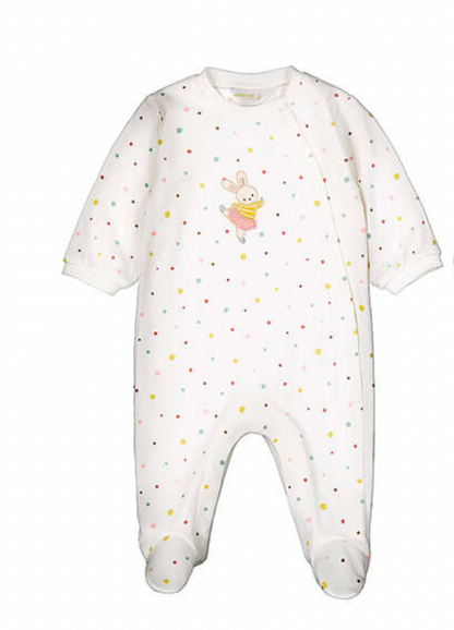 A white footed baby jumpsuit with a multicolor polka dot pattern and a small bunny graphic on the chest, shown against a plain white background.