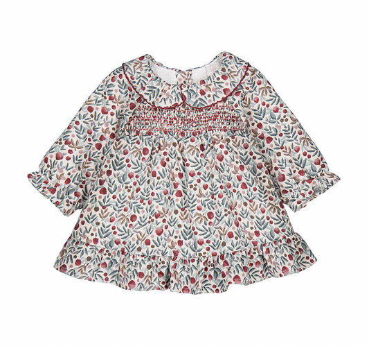 A baby girl's long-sleeve smocked blouse with a delicate red berry and green leaf pattern on an off-white background, featuring a ruffled collar and ruffled hem.