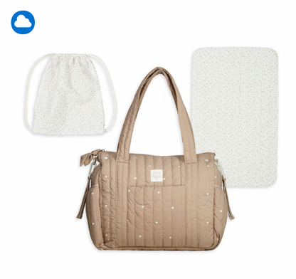 A quilted beige diaper bag with white polka dots is shown with two matching accessories on a white background: a drawstring bag and a changing pad. A small cloud icon appears in the top-left corner.