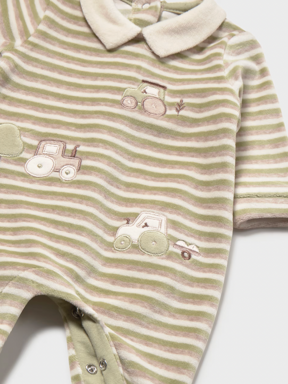 A close-up of a baby's short-sleeve footless romper featuring horizontal sage green and beige stripes with embroidered tractor motifs and a cream-colored collar.