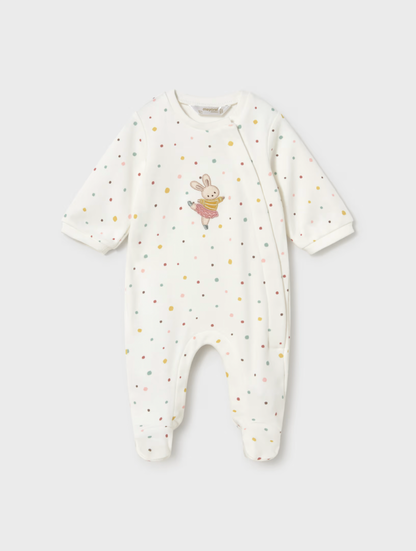 A baby long-sleeve footless sleeper in off-white, decorated with small multicolored polka dots and a cute bunny graphic on the chest, shown against a light gray background.