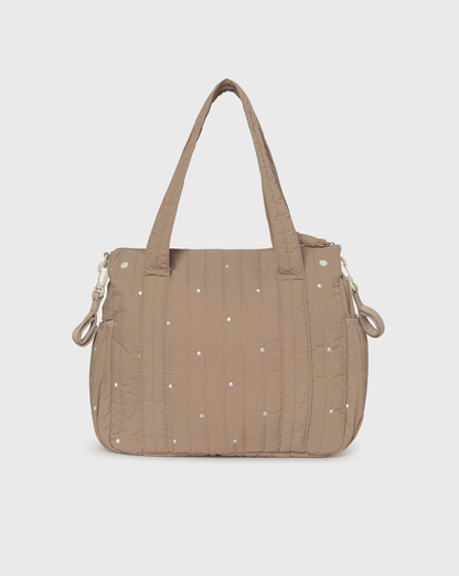 A taupe quilted puffer handbag with small white embroidered dots, dual top handles, and silver-tone hardware, shown against a light gray background.