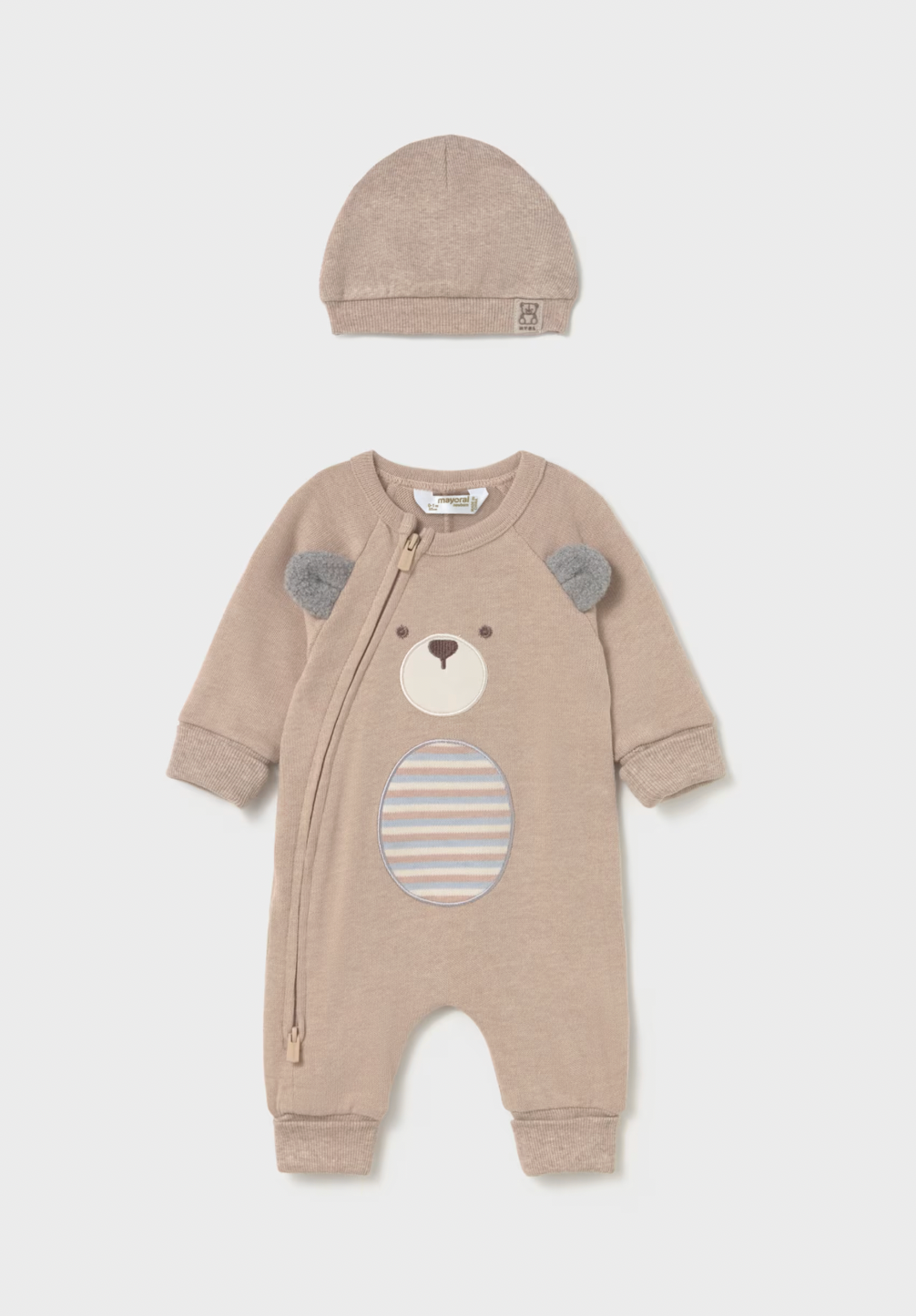 A baby two-piece outfit set consisting of a long-sleeve footless zip-up sleeper and a matching beanie. The sleeper is a light taupe color with a bear face applique on the front featuring gray ears and a striped circular patch on the belly.