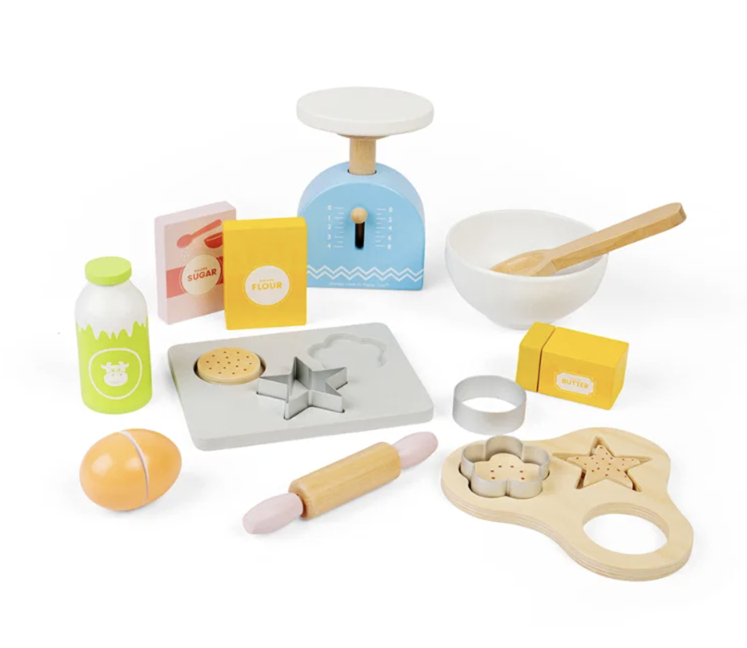 A children's wooden play kitchen baking set arranged on a white background. The set includes a blue scale, white bowl with wooden spoon, milk bottle, flour box, sugar box, cookie cutters, rolling pin, egg, and other small baking accessories.