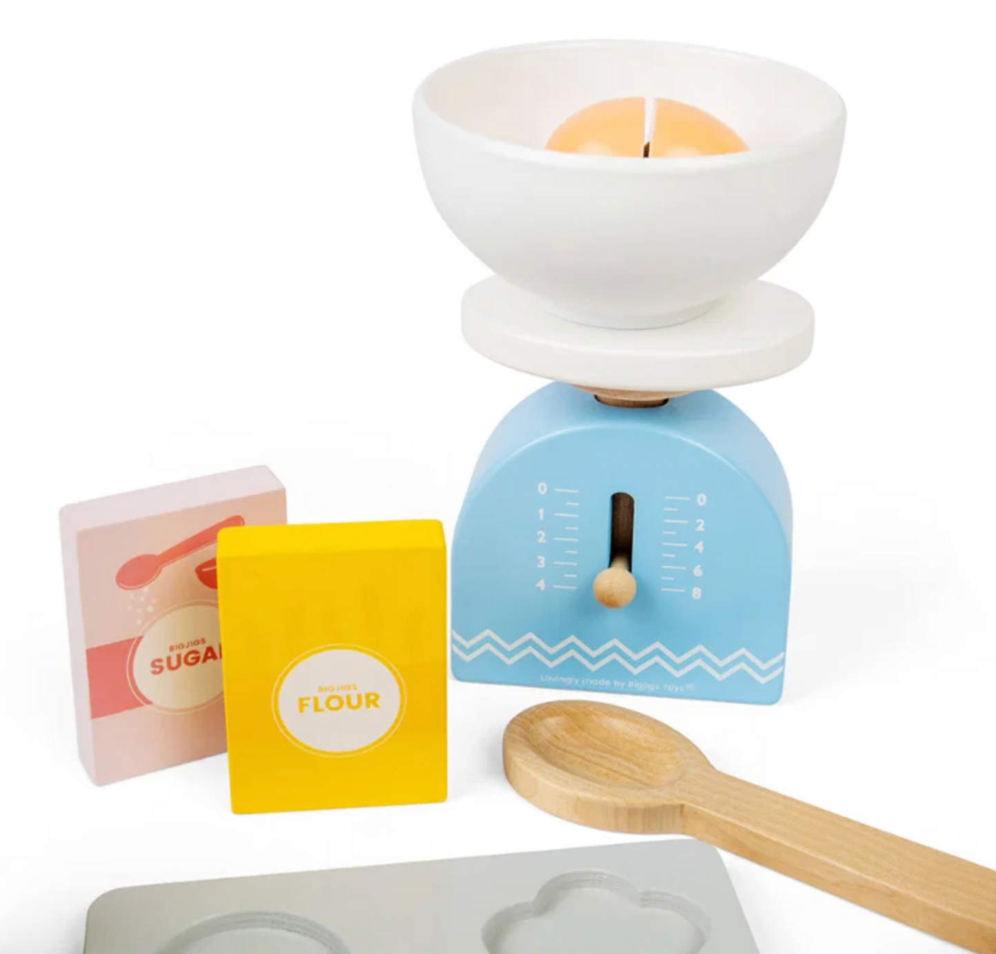 A children's wooden baking play set on a white background, featuring a blue scale with a white mixing bowl, a yellow flour box, a pink sugar box, a wooden spoon, and a gray mold tray.