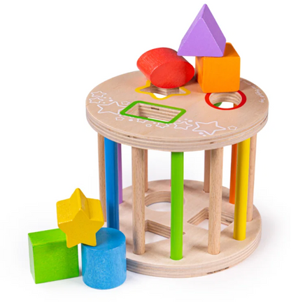 A wooden shape-sorting toy for toddlers with a round peg-hole table, colorful vertical pegs, and loose geometric blocks including a purple triangle, red oval, orange cube, green rectangle, yellow star, and blue cylinder on a white background.