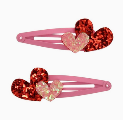 Two pink hair clips with glittery red and holographic heart accents, displayed on a clean white background.