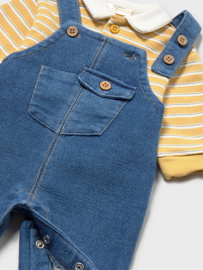 A baby clothing set featuring blue denim overall-style overalls layered over a yellow and white striped short-sleeve shirt with a white collar, shown on a light gray background.
