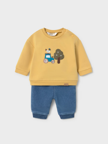 A children's two-piece outfit set featuring a yellow sweatshirt with a blue tractor and tree graphic on the chest, paired with blue pants, shown against a light gray background.