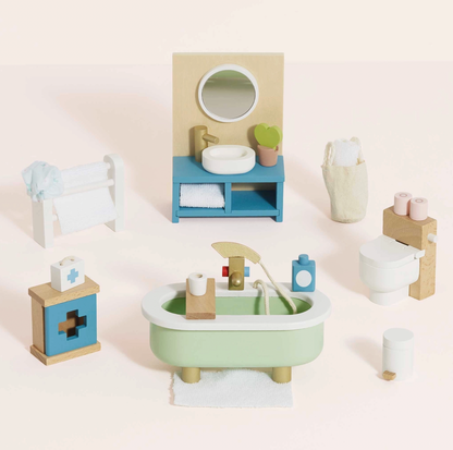 Le Toy Van wooden bathroom dolls house furniture set — styled scene showing sage green roll-top bath with gold tap fittings, teal vanity unit with round mirror and heart-leaf cactus, white toilet with pink toilet rolls, blue first aid cabinet and white towel rail