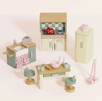 Le Toy Van 20-piece kitchen dolls house furniture set — styled scene showing cream cooker unit with sage green checkerboard splashback and red polka-dot kettle, sage green sink unit with pink gingham curtain, cream retro fridge-freezer, wooden kitchen island with two sage green bar stools, and pink mop and dustpan set