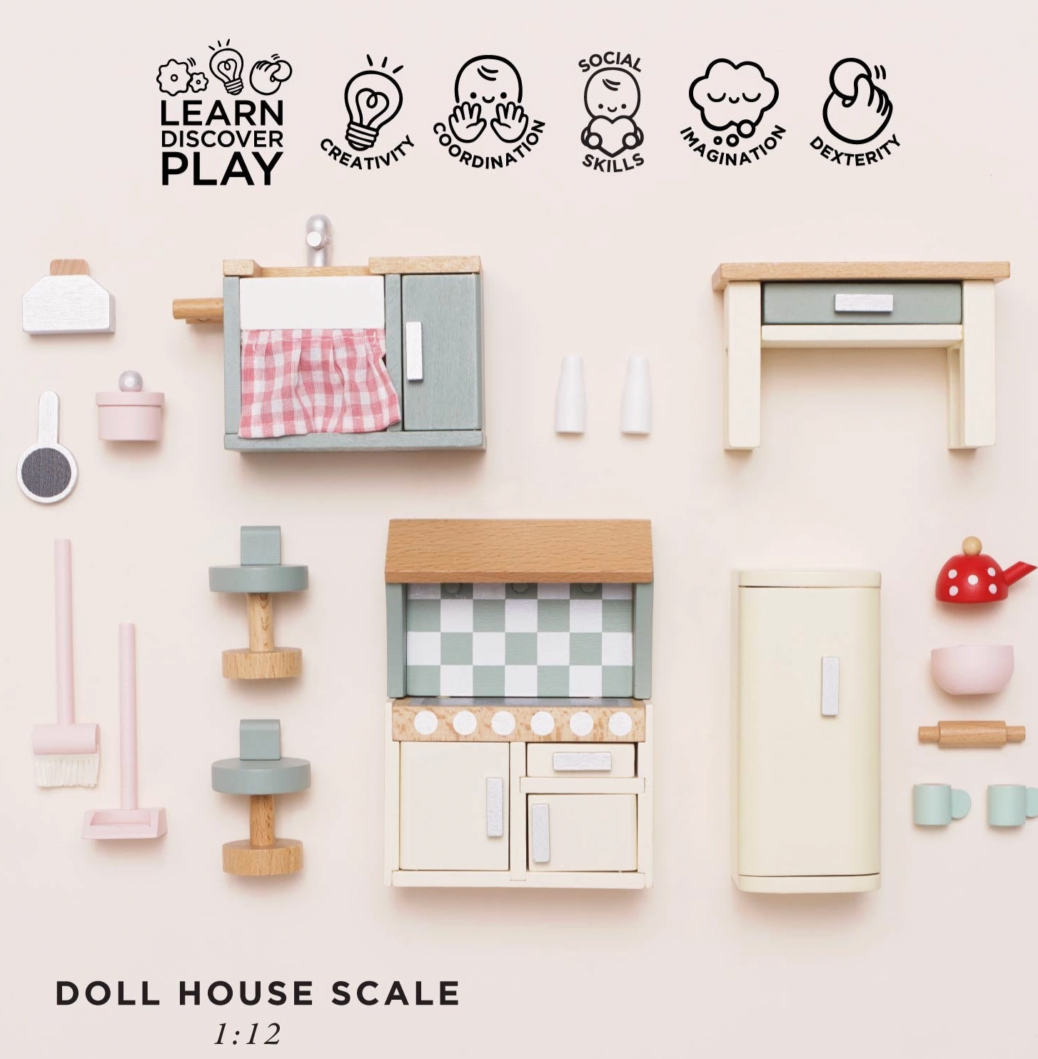 Le Toy Van kitchen dolls house furniture set — flat lay of all 20 pieces with "Doll House Scale 1:12" label and play skills icons for creativity, coordination, social skills, imagination and dexterity; showing sink unit, cooker, fridge, kitchen island, bar stools, red polka-dot kettle, pink mixing bowl, rolling pin, sage green mugs and pink mop set
