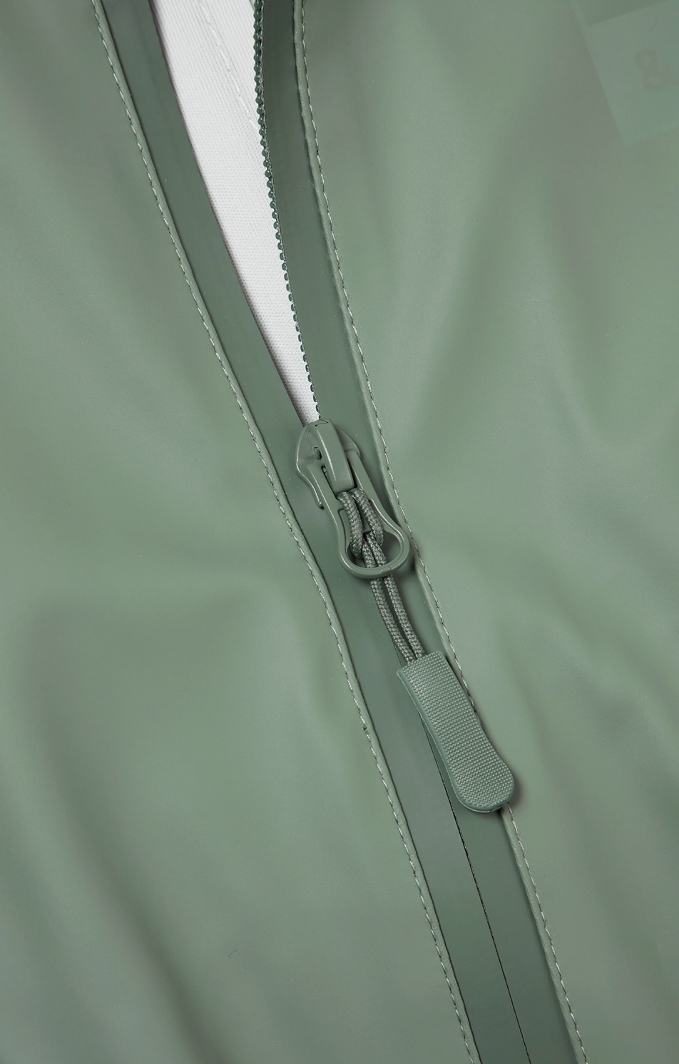 Grass & Air children's waterproof puddle suit — close-up detail of the waterproof front zip with easy-grip pull tab, showing the taped waterproof seam construction