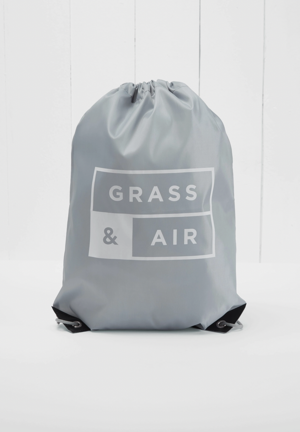 Grass & Air branded grey drawstring storage bag included with the Ruby Colour-Changing Wellies — grey nylon bag with white Grass & Air logo print