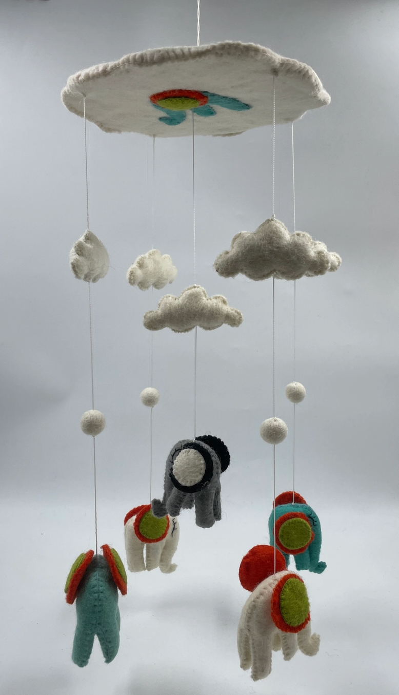 Funky Yak handmade needle-felted elephant nursery cot mobile — full view from a distance showing the complete mobile hanging freely, approximately 47cm from the cloud-shaped hoop to the lowest elephant