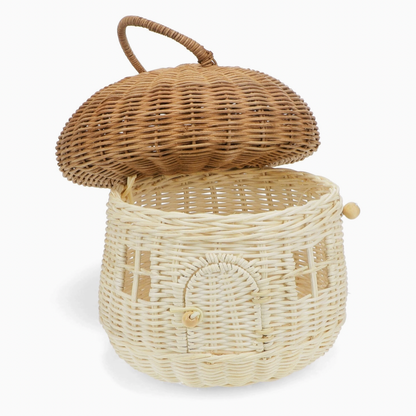 Rex London Wonders of Nature rattan mushroom house decorative basket — open view with the honey-brown domed cap lifted off and tilted to the side, revealing the generous open storage basket interior; pale cream woven body with arched doorway and wooden bead closure visible
