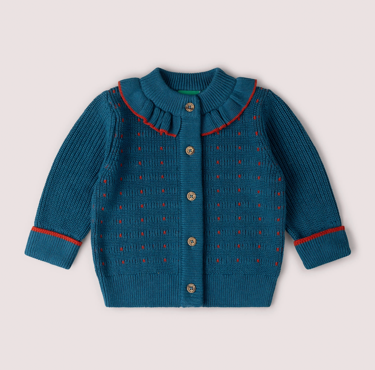 Little Green Rascals Midnight Frill Snuggly Cardigan — front flat lay showing rich midnight teal chunky organic cotton knit with scattered red dash stitch pattern throughout, knitted ruffle frill collar with red contrast edge trim, five branded Little Green Rascals coconut shell buttons down the front, ribbed cuffs with red contrast stripe, and ribbed hem; Little Green Rascals green woven label at the back neck