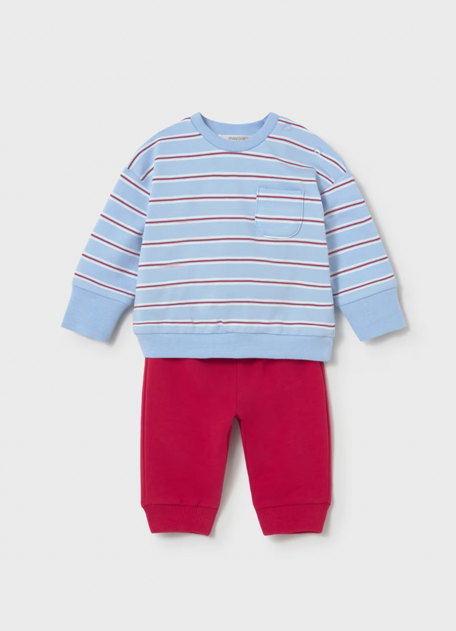 Mayoral boys nautical stripe 2-piece set — styled flat lay on grey background showing a sky blue cotton pullover with horizontal nautical stripes in alternating red and white, right chest patch pocket, ribbed round neckline, ribbed cuffs and ribbed hem; paired with bold solid red joggers with elasticated waist and ribbed ankle cuffs
