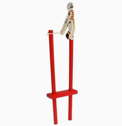 Red wooden frame; figure upright seated on top of the trapeze bar; same detail; upright seated pose