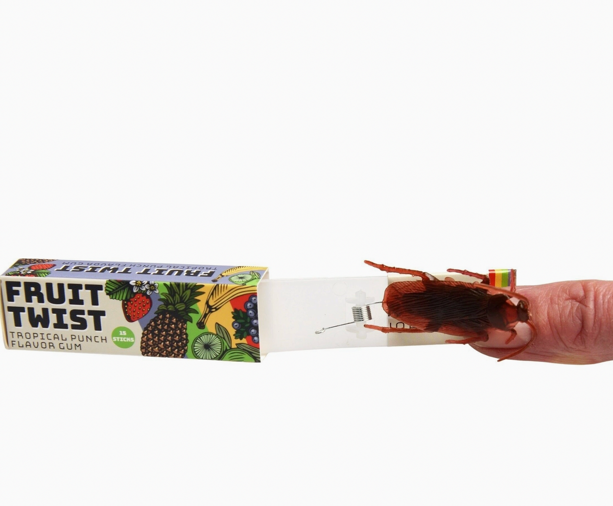  Action shot — hand pulling the drawer; cockroach mid-launch with legs splayed; spring extended; prank being triggered