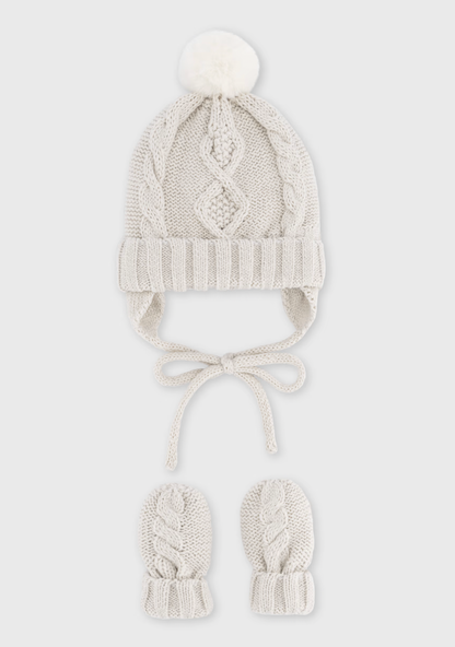 Grey background product shot — hat and mittens upright; the cleanest, most polished version of the set