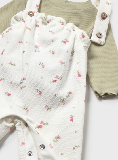 Close-up detail — bib, strap, brown buttons, seersucker print detail, inner leg popper visible
