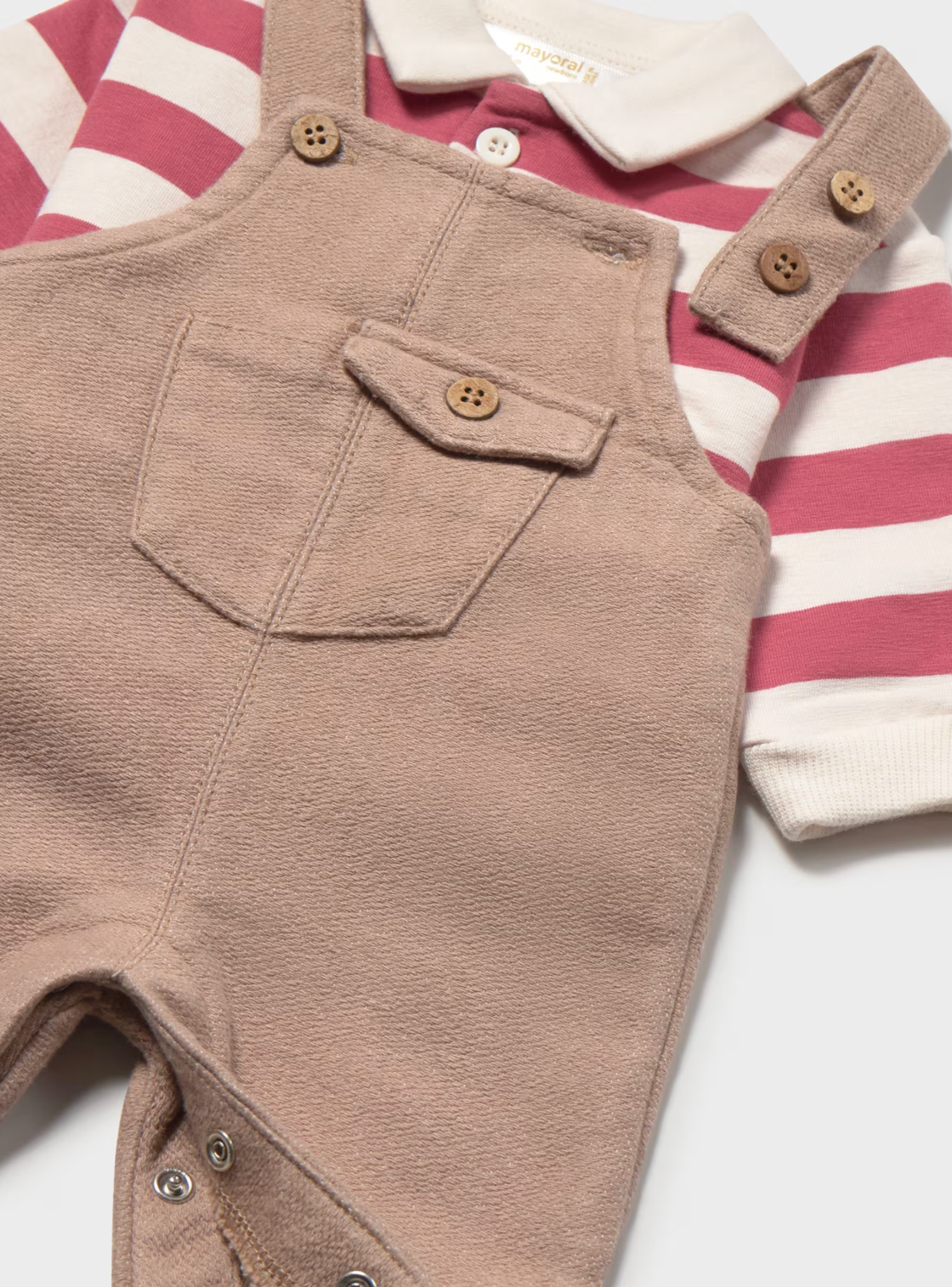 Close-up detail — brushed camel fabric texture; bib pocket with button flap; two buttons per strap; inner leg poppers; Mayoral label
