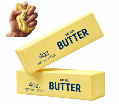 Super Star Butter Squishy slow-rising squishy toy shown in two product views on a white background with an inset squeeze demonstration; main image: two butter squishy blocks arranged at angles — one tilted forward showing the top face with SALTED BUTTER in large bold navy lettering and a second block flat behind it showing the 4 OZ. NET WT. (113G) text on the side; both in bright butter-yellow soft foam with rounded edges; inset image upper left: a hand gripping one butter squishy block in a tight fist, the
