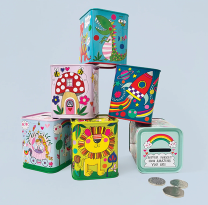 Child emptying coins from a Rachel Ellen dinosaur money box while another blue dinosaur tin sits nearby with coins scattered on the floor