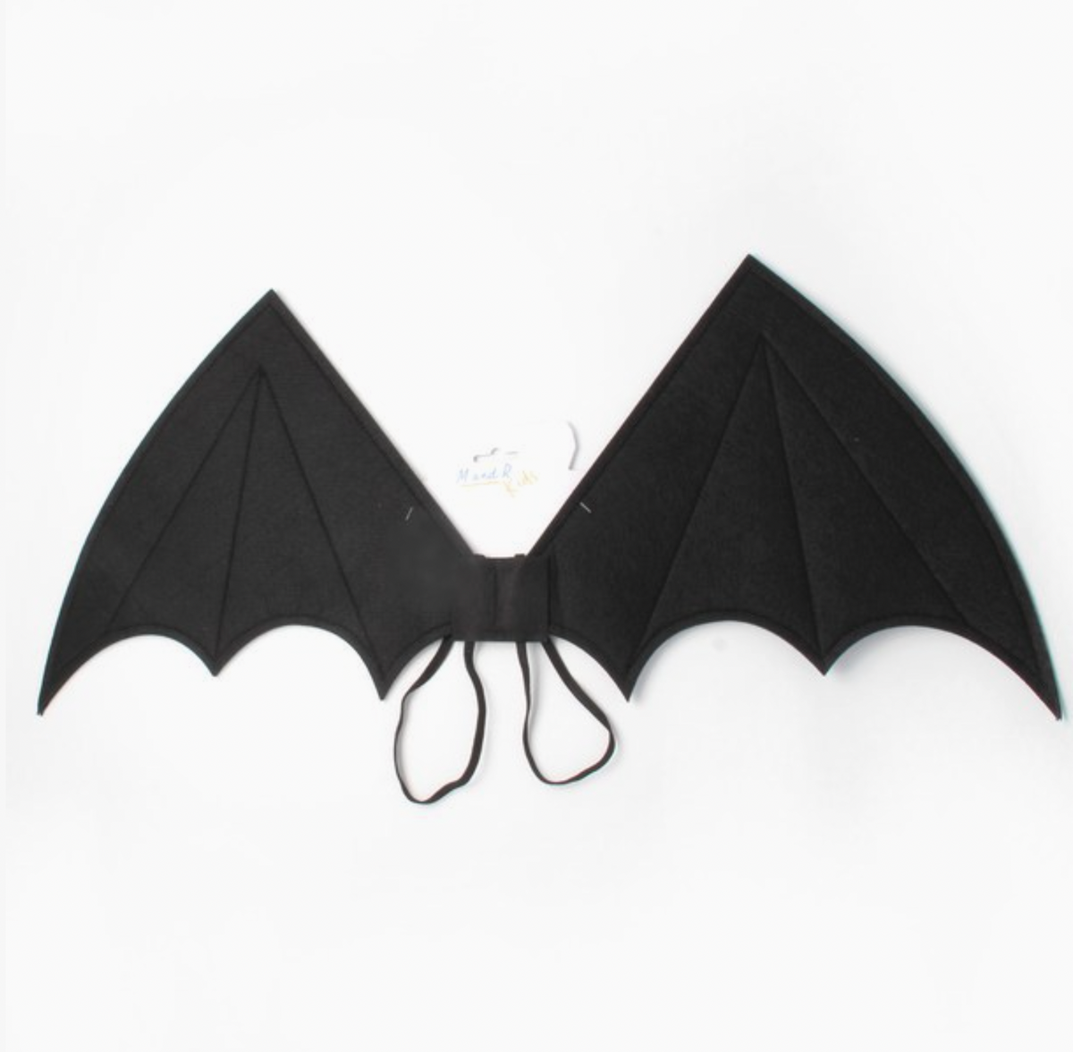 Child wearing Molly & Rose black fabric bat wings over a checked dress; pointed wing tips, scalloped lower edges, stitched panel lines and black elastic straps visible
