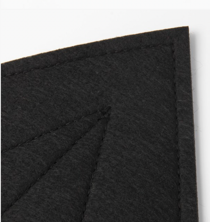 Close-up of Molly & Rose black polyester bat-wing fabric showing the dark woven texture and stitched panel detailing⠋