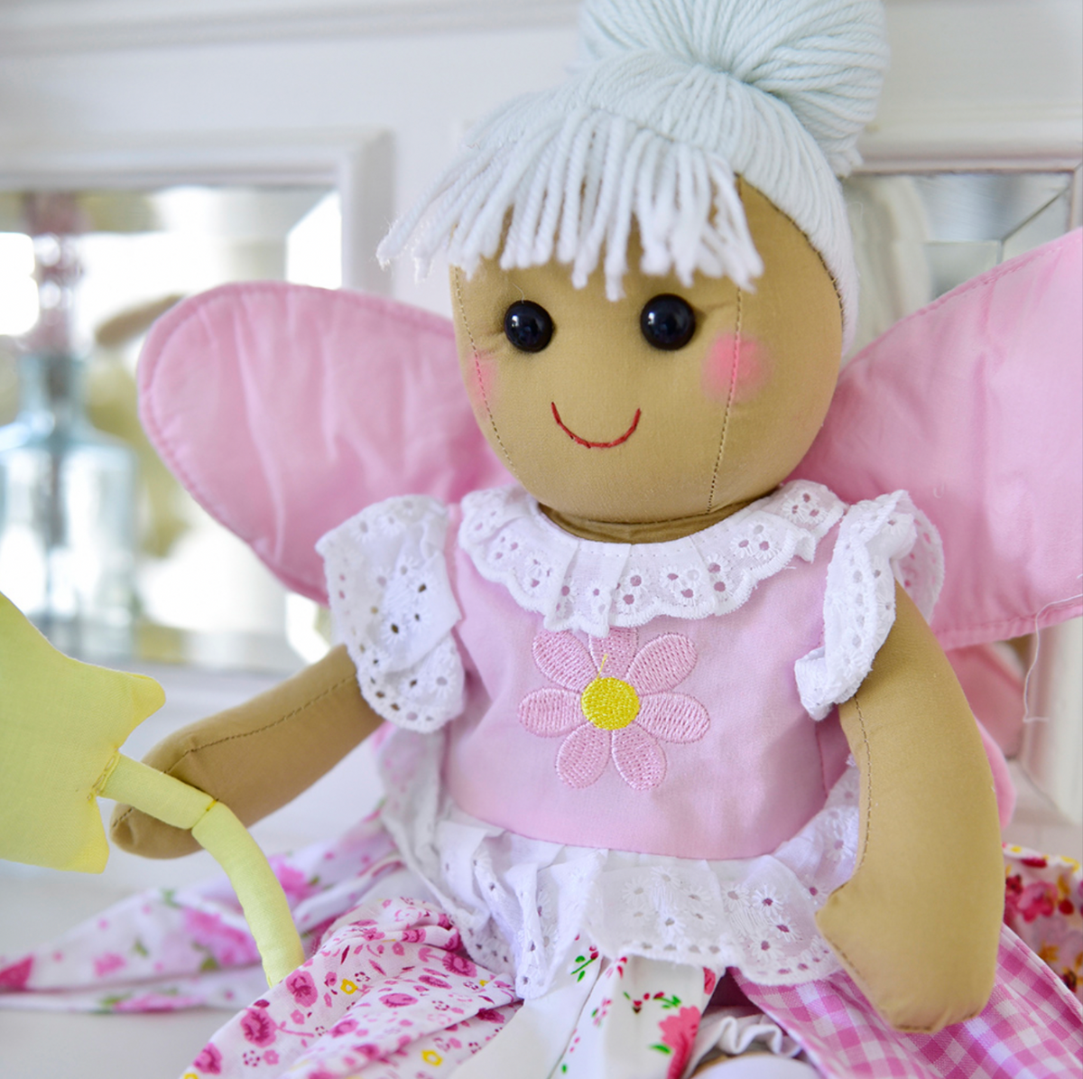 Powell Craft fabric fairy doll with blonde hair in a bun, pale pink fairy wings and shoes, and a yellow wand.