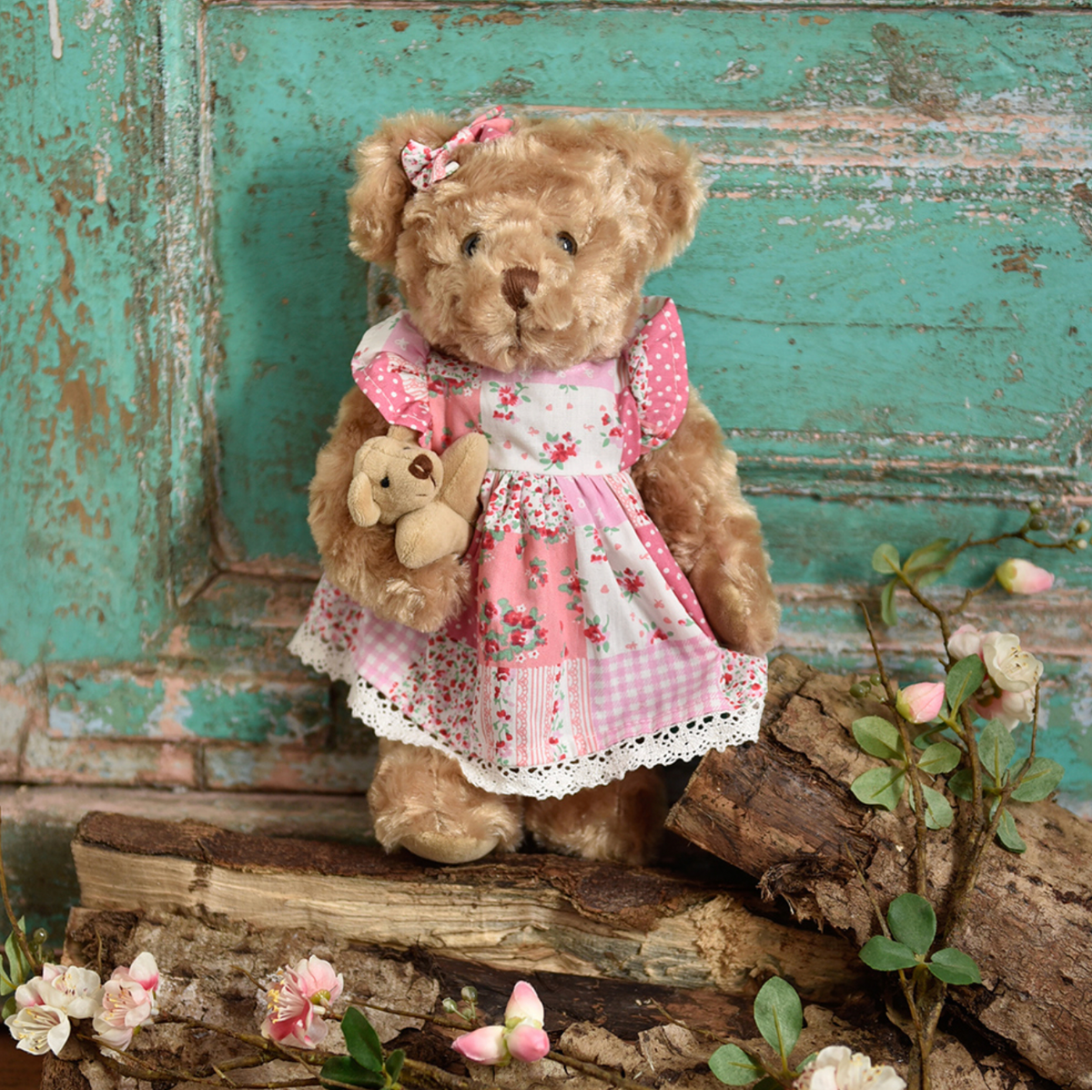 Powell Craft soft teddy bear in a pink patchwork dress, with velvety paws, embroidered mouth and nose, fixed eyes and a tiny teddy bear.