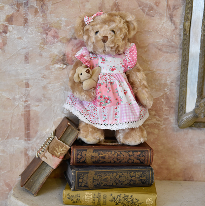 Pink patchwork dress teddy by Powell Craft, with mixed polka-dot, check, stripe and floral fabrics, crochet-lace hem and a matching ear bow.