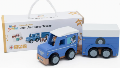 Jumini blue wooden jeep and twin-axle horse trailer with fitted white roofs in front of rope-handled gift box; black wheels with grey hubs, natural wood chassis, printed dog in jeep window, peg person in cab and JUMINI front plate. Box reads Farm collection, Jeep And Horse Trailer and 18m+.