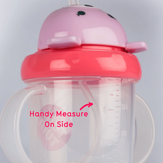 Pink and clear sippy cup with measurement markings. TIPPY CUP WITH STRAW AND FLIP TOP LEAKPROOF LID - PINK BETSY BEAR | TUM TUM