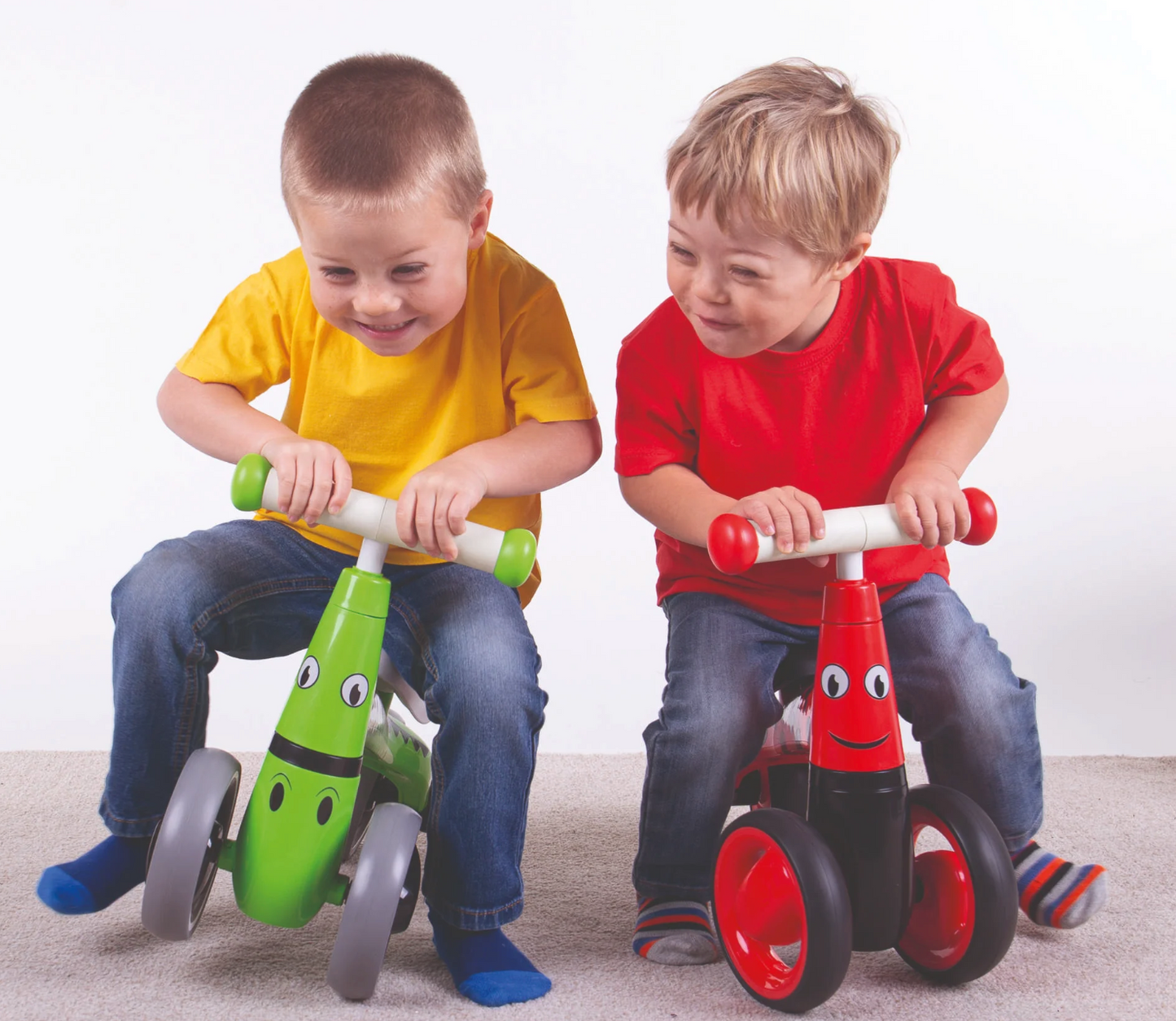 Two children riding colorful balance bikes against. TODDLER RIDE ON TOY - LADYBIRD | DIDITRIKE 