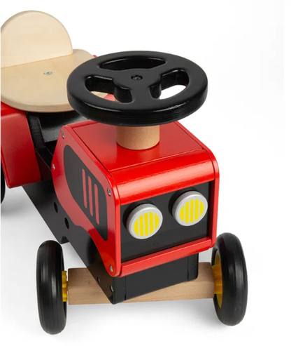 Toy car with steering wheel and red body. TODDLER RIDE ON WOODEN TRACTOR - RED | BIGJIGS