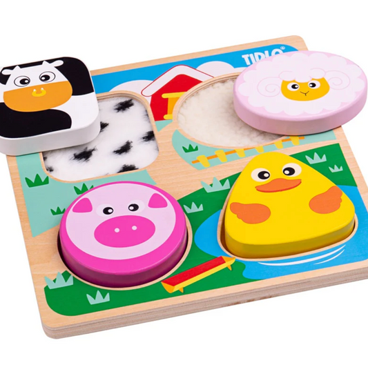 A wooden touch and feel farm puzzle featuring pieces with animal shapes such as a duck, cow, pig, and sheep, along with tactile textures like woolly lamb and feathery duck. TOUCH & FEEL FARM PUZZLE | TIDLO