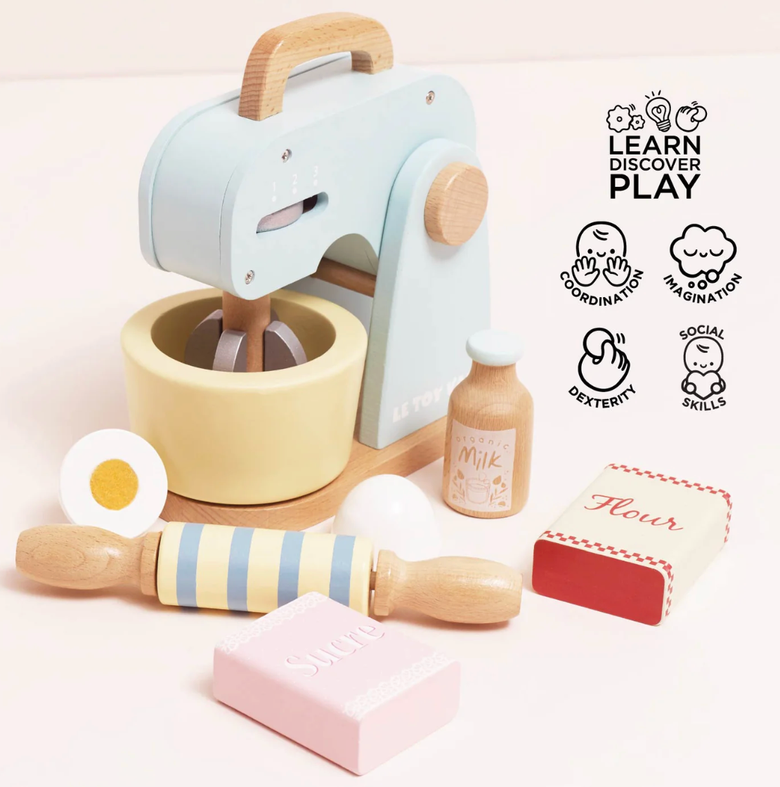 Wooden play kitchen set with mixer, rolling pin, and ingredients on a light pink background. TOY BAKERS MIXER SET AND ACCESSORIES | LE TOY VAN
